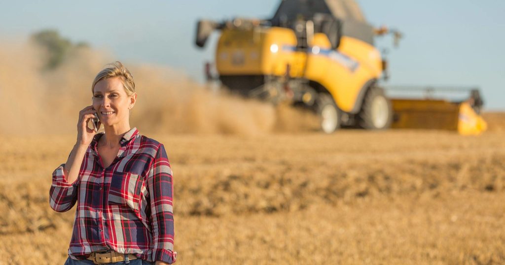 Woman in grain field on a call | Grain Brokers